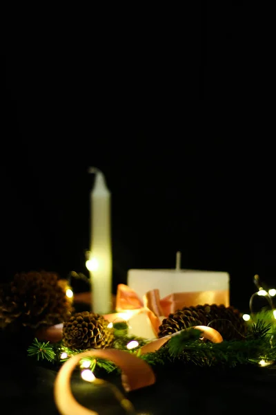 Rosafarbene Weihnachtsdekoration mit Kerzen auf schwarzem Hintergrund — Stockfoto