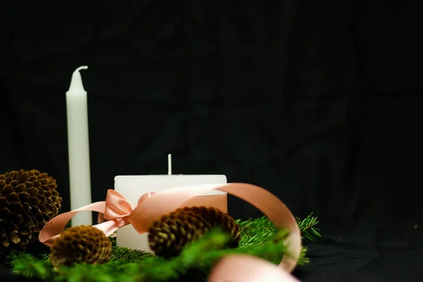 Decoraciones navideñas rosas con velas sobre fondo negro — Foto de Stock