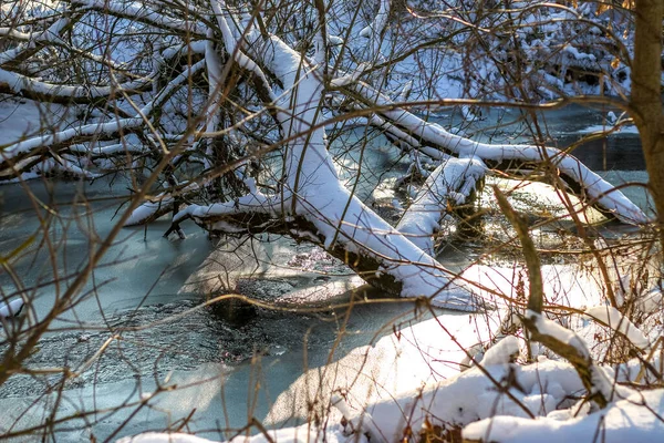 Śnieg pada na rzekę ze śnieżnymi brzegami — Zdjęcie stockowe