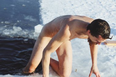 Genç, zayıf, yakışıklı, kızıl sakallı, uzun saçlı, siyah şortlu, kışın buz gibi sulara dalan Ukrayna, Shostka