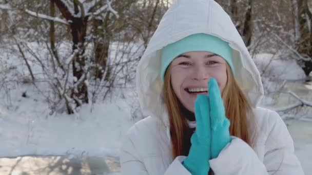 Портрет забавной и милой молодой женщины, подлинного реального человека в солнечный снежный зимний день, — стоковое видео