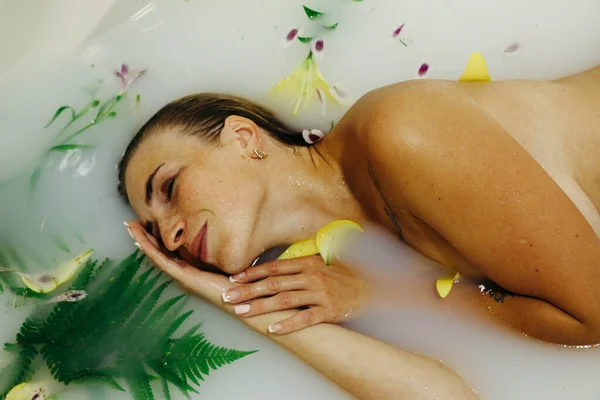 Schöne Mädchen Einer Badewanne Mit Milchwasser Mit Blumen Und Blättern — Stockfoto
