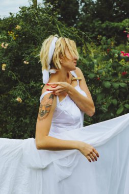 Kurutulmuş çamaşır. Genç ve güzel bir kadın, güneşli bir günde elbiselerini yıkar ve dışarı asar..