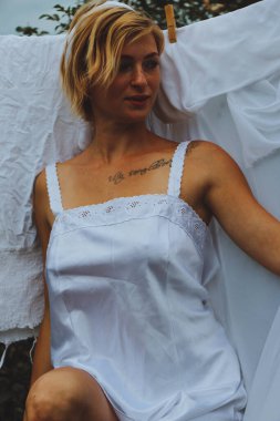 Kurutulmuş çamaşır. Genç ve güzel bir kadın, güneşli bir günde elbiselerini yıkar ve dışarı asar..