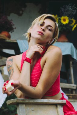 Kurutulmuş çamaşır. Genç, güzel, seksi bir kadın güneşli bir günde çamaşırlarını yıkar ve iç çamaşırlarını dışarı asar. Kırmızı elbiseli..