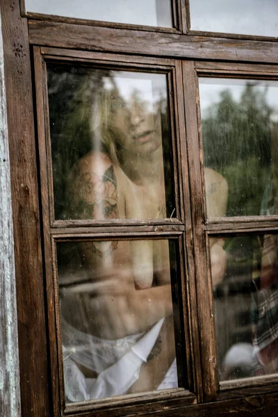 美しい若い女性の美しい肖像画悲しいことに古い窓を通ってグランジスタイル — ストック写真