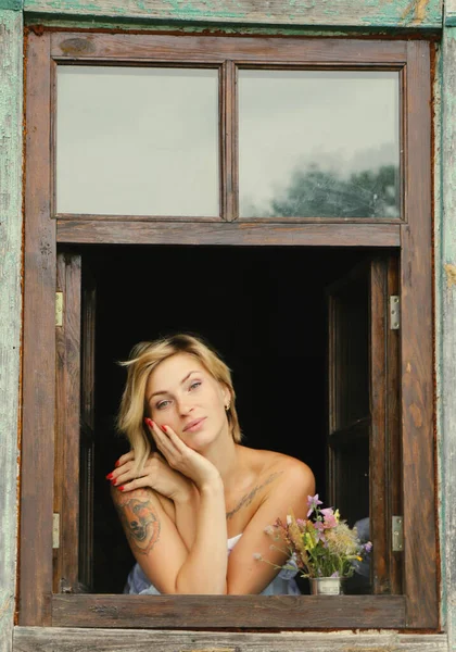 美しい若い女性の芸術の肖像画は 古い窓の外を見ると グランジスタイルの窓辺に座っている — ストック写真