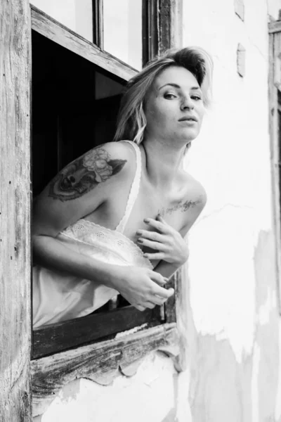 美しい若い女性の芸術の肖像画は 古い窓の外を見ると グランジスタイルの窓辺に座っている — ストック写真
