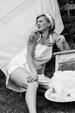 Kurutulmuş çamaşır. Genç, güzel, seksi bir kadın güneşli bir günde çamaşırlarını yıkar ve iç çamaşırlarını dışarı asar. siyah beyaz fotoğraf.