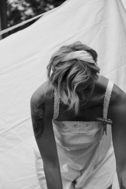 Kurutulmuş çamaşır. Genç, güzel, seksi bir kadın güneşli bir günde çamaşırlarını yıkar ve iç çamaşırlarını dışarı asar. siyah beyaz fotoğraf.