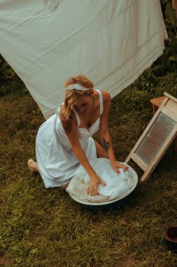 Kurutulmuş çamaşır. Genç, güzel, seksi bir kadın güneşli bir günde çamaşırlarını yıkar ve iç çamaşırlarını dışarı asar. siyah beyaz fotoğraf.