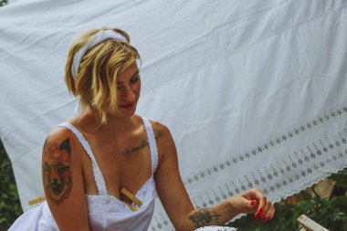 Kurutulmuş çamaşır. Genç, güzel, seksi bir kadın güneşli bir günde çamaşırlarını yıkar ve iç çamaşırlarını dışarı asar. siyah beyaz fotoğraf.