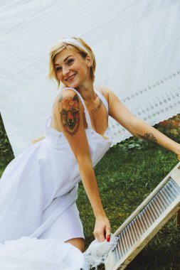 Kurutulmuş çamaşır. Genç, güzel, seksi bir kadın güneşli bir günde çamaşırlarını yıkar ve iç çamaşırlarını dışarı asar. siyah beyaz fotoğraf.