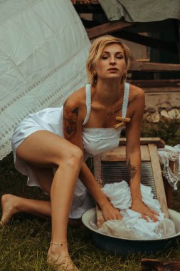 Kurutulmuş çamaşır. Genç, güzel, seksi bir kadın güneşli bir günde çamaşırlarını yıkar ve iç çamaşırlarını dışarı asar. siyah beyaz fotoğraf.