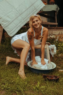 Kurutulmuş çamaşır. Genç, güzel, seksi bir kadın güneşli bir günde çamaşırlarını yıkar ve iç çamaşırlarını dışarı asar. siyah beyaz fotoğraf.