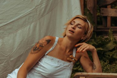 Kurutulmuş çamaşır. Genç, güzel, seksi bir kadın güneşli bir günde çamaşırlarını yıkar ve iç çamaşırlarını dışarı asar. siyah beyaz fotoğraf.