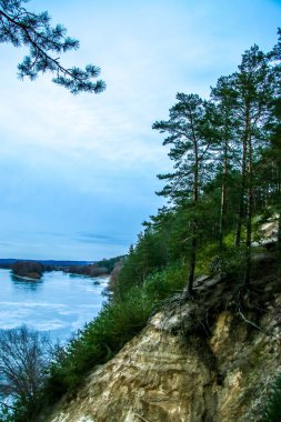 Buz ve karla kaplı donmuş nehir, üst manzara. Çam ağaçlı Sandy Hill. Kış ormanı ve nehir, karlı doğa. Kış dondurucu soğuk. güzel buz dokusu