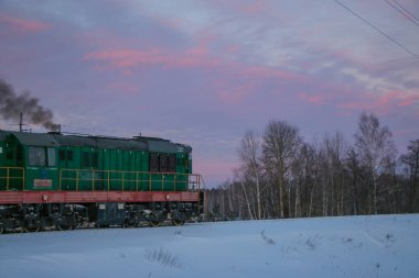 Eski yolcu treni soğuk bir kış akşamı gün batımında istasyona varır.