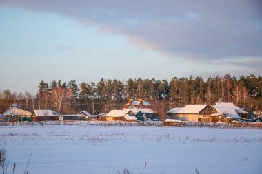 Kış manzarası karlı dağlar, barınak ve vadi mavi gökyüzü, gün batımı. Eski evler, çitler ve yollar. Putivsk köyü, Chernigov olast, Ukrayna
