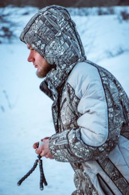 Telefonlu bir adam Zidio 'nun kış günbatımının hızlandırılmış fotoğraflarını çekiyor. Tarla, yol ve ağaçlar karla kaplı..