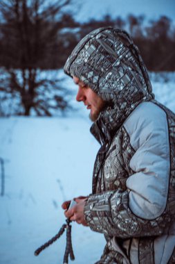 Telefonlu bir adam Zidio 'nun kış günbatımının hızlandırılmış fotoğraflarını çekiyor. Tarla, yol ve ağaçlar karla kaplı..