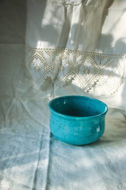 Pamuk dantelli romantik keten çay havluları ve şık bir ev ya da restoran servisi için koyu mavi bir tabak. Güzel arka plan, doğal güneş ışığı modeli, gölgeler.