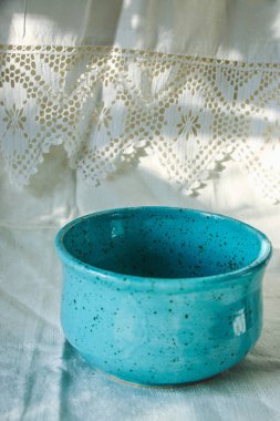 Pamuk dantelli romantik keten çay havluları ve şık bir ev ya da restoran servisi için koyu mavi bir tabak. Güzel arka plan, doğal güneş ışığı modeli, gölgeler.