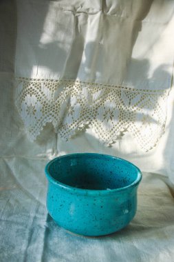 Pamuk dantelli romantik keten çay havluları ve şık bir ev ya da restoran servisi için koyu mavi bir tabak. Güzel arka plan, doğal güneş ışığı modeli, gölgeler.