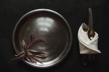 yuvarlak metal plaka, siyah arka planda antika gümüş eşyalar güneş ışığı, gölge. Mutfak masası manzarası, masa düzenleme. Pervazlı bitki dalı Güzel retro, rustik arkaplan, serbest alan.