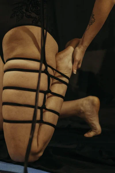 Submission slave woman legs bound in erotic fashion style rope shibari kinbaku Japanese bondage knot. Bdsm sadomasochism mistress master dominant fetish punishment flogging sadism masochism concept.