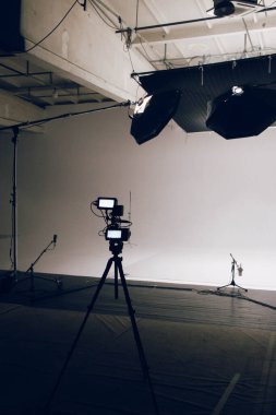 Profesyonel ekipmanların iş için hazırlandığı büyük ve modern bir video stüdyosunun içi. Kamera ön planda.