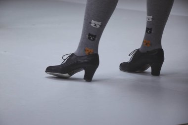 Siyah ayakkabılı flamenko dansçısı ayakları, beyaz arka planda, yakın plan