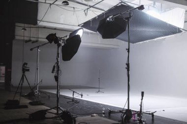 Profesyonel ekipmanların iş için hazırlandığı büyük ve modern bir video stüdyosunun içi. Önplan ekipmanları, mikrofonlar, kablolar ve ışıklandırma kurulumları
