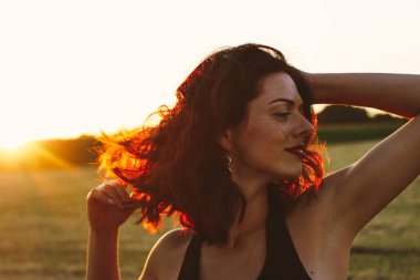 Güneşli bir yaz akşamında, gün batımında, siyah elbiseli genç ve güzel bir esmer. Çekici bir kadın dans ediyor, arka planda biçilmiş buğday gibi poz veriyor..