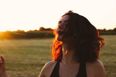 Güneşli bir yaz akşamında, gün batımında, siyah elbiseli genç ve güzel bir esmer. Çekici bir kadın dans ediyor, arka planda biçilmiş buğday gibi poz veriyor..