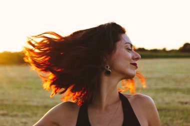 Güneşli bir yaz akşamında, gün batımında, siyah elbiseli genç ve güzel bir esmer. Çekici bir kadın dans ediyor, arka planda biçilmiş buğday gibi poz veriyor..