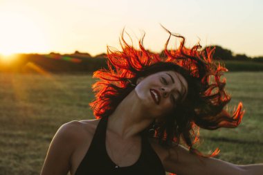 Güneşli bir yaz akşamında, gün batımında, siyah elbiseli genç ve güzel bir esmer. Çekici bir kadın dans ediyor, arka planda biçilmiş buğday gibi poz veriyor..