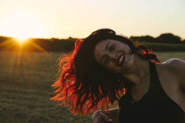 Güneşli bir yaz akşamında, gün batımında, siyah elbiseli genç ve güzel bir esmer. Çekici bir kadın dans ediyor, arka planda biçilmiş buğday gibi poz veriyor..