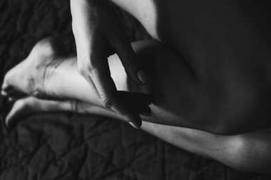 Ayaklarında kına dövmesi olan kadın bacaklarının ve ellerinin yakın çekimi. Siyah beyaz fotoğraf. Nazikçe kadınsı zarif dekorasyon, bir kadına saygı, sevgi ve kendine dikkat et..