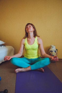 Yetişkin güzel Avrupalı kadın evde yoga yapıyor. Bir dizi yoga pozu. Meditasyon yapıyor Pranayama nefes egzersizi Ardha Padmasana Sağlıklı yaşam tarzı konsepti,