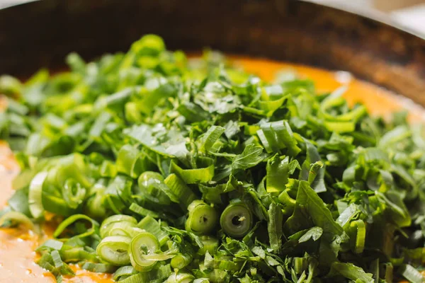 Metal bir tavada Shahi paneer sosu: domates soslu geleneksel bir Hint paneer peyniri tabağı. Ve bir sürü yeşillik. Üst görünüm kapat