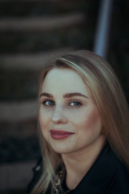 Mavi gözlü güzel bir sarışının portresi. Siyah elbiseli.