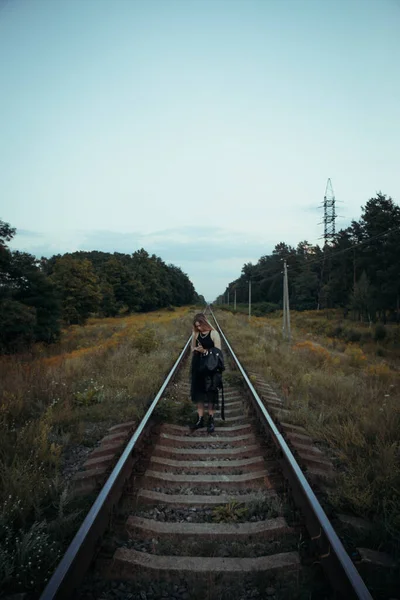 黒い服の若い美しい少女は 鉄道線路の上 良い気分で美しいブロンド 美しい自然の柔らかい夜の光 — ストック写真