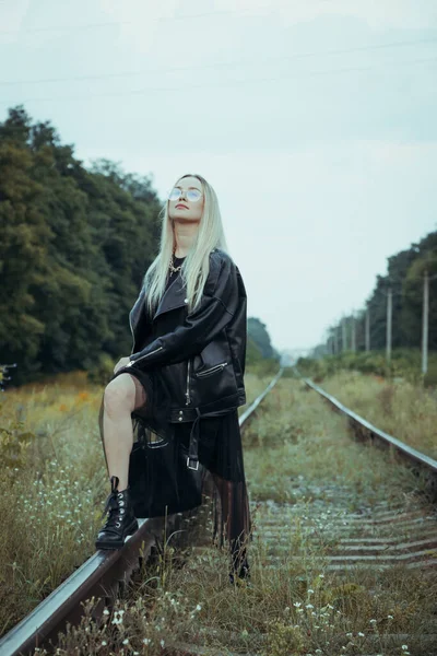 黒い服の若い美しい少女は 鉄道線路の上 良い気分で美しいブロンド 美しい自然の柔らかい夜の光 — ストック写真