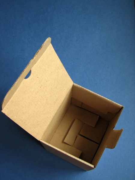 Kartonová krabice na tmavě modrém pozadí — Stock fotografie
