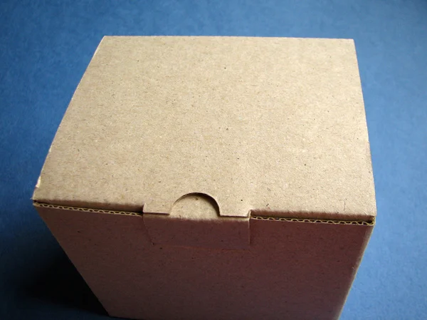 Cardboard Box on a dark blue background — Stock Photo, Image