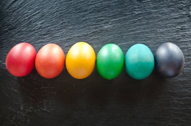 Siyah taşın üstünde altı Paskalya yumurtası. Düz görünüm fotoğrafı.