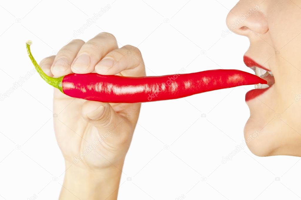 Woman with red chili pepper in her teeth isolated on white