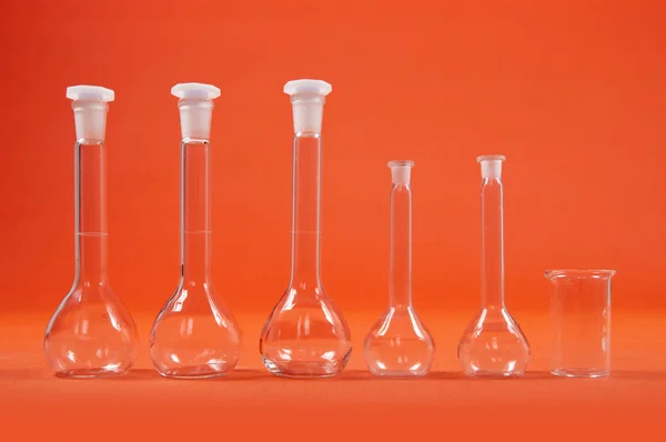 Χημεία επιστήμη - φιάλες σε πορτοκαλί φόντο — Φωτογραφία Αρχείου