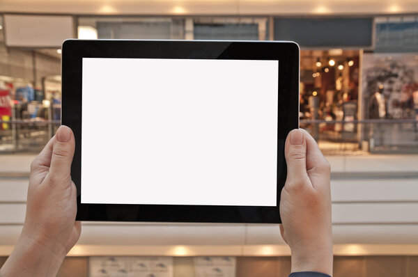 Tablet PC with empty screen in woman hand, shopping center